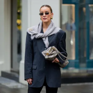 BERLIN, GERMANY - OCTOBER 08: Tina Haase wears vintage black oversize blazer, Black stirrup leggings, taupe knit triangle scarf Massimo Dutti, Loewe brooch, taupe grey Prada Bag on October 08, 2025 in Berlin, Germany. (Photo by Christian Vierig/Getty Images)