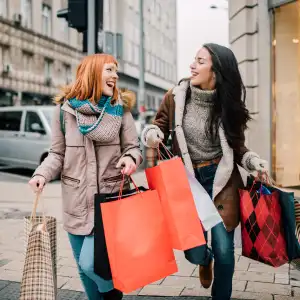 Happy two girls holding bunch of shopping bags