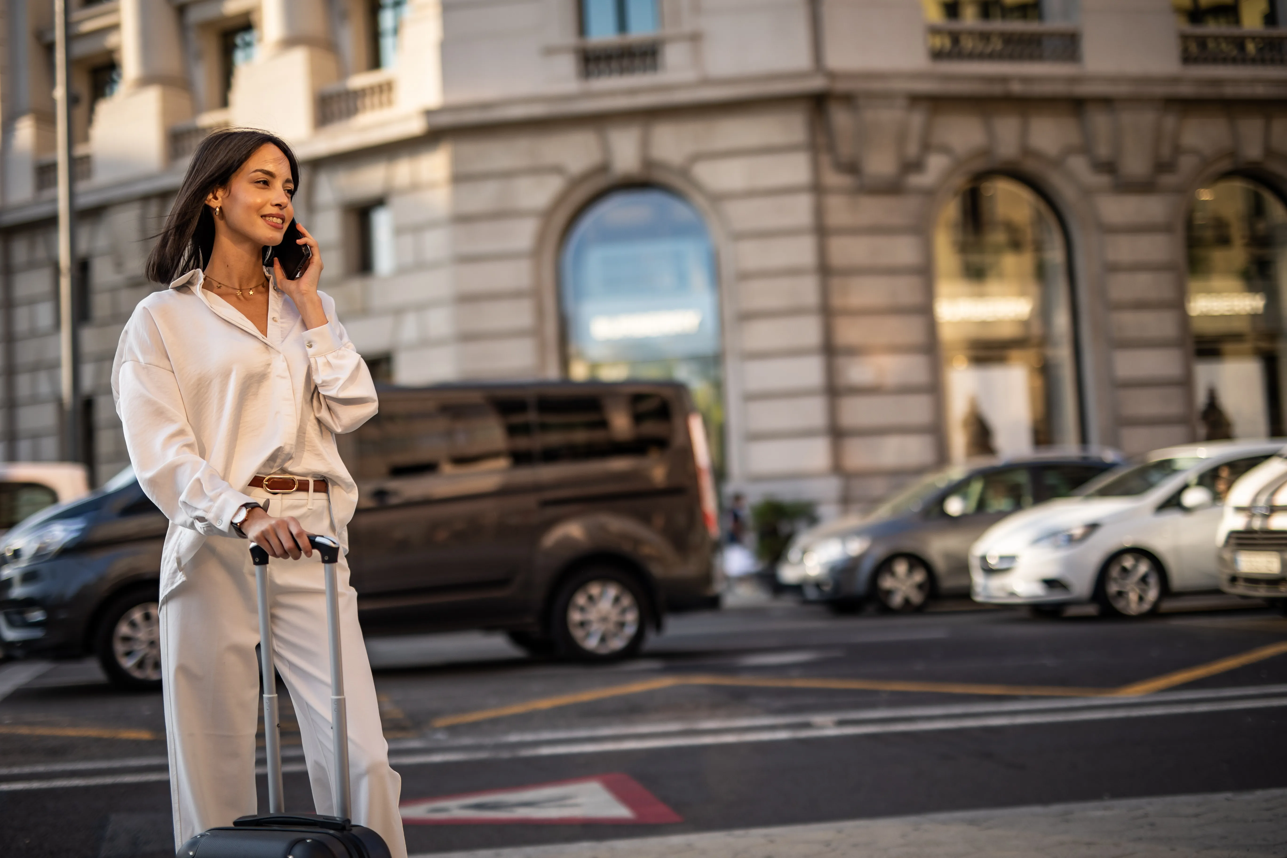 A happy pretty woman is walking on the street of Barcelona and enjoying a nice autumn day in the big city.