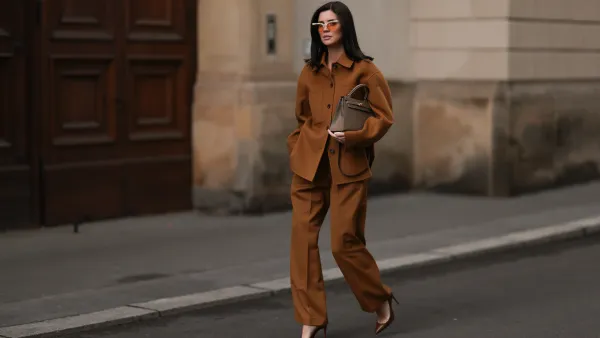 Leo Eberlin is seen wearing half-rimless cat-eye sunglasses with orange lenses and a grey structured top-frame from & Other Stories; a brown two-piece from Arket, consisting of a jacket with dark brown button placket, collar, and large chest pockets, a wide-legged pants with crease; a beige leather “Kelly“ bag from Hermès; and pointed brown leather high heels from Christian Loubouti on October 03, 2024 in Berlin, Germany.