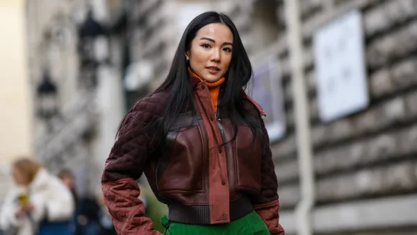 PARIS, FRANCE - MARCH 05: Yoyo Cao wears an orange ribbed wool turtleneck pullover, a brown shiny leather / black leather straps / quilted sleeves zipper jacket, green large ribbed velvet large pants, outside Hermes , during Paris Fashion Week - Womenswear F/W 2022-2023, on March 05, 2022 in Paris, France. (Photo by Edward Berthelot/Getty Images)