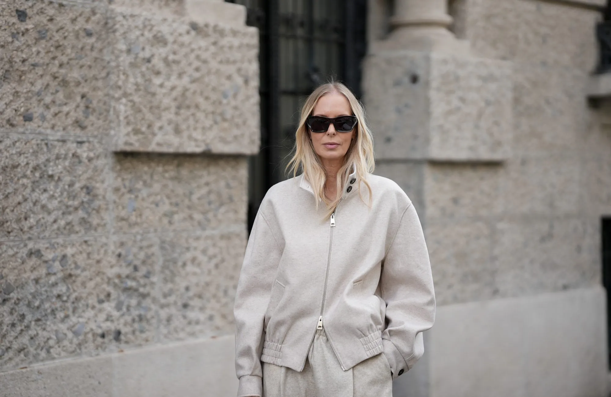 MILAN, ITALY - SEPTEMBER 25: Mirja Klein is seen wearing a beige wool zip-up bomber jacket with a high collar and elastic waistband by Liviana Conti; beige wide-leg wool trousers in a relaxed silhouette by Liviana Conti; an off-white structured leather handbag with top handles and a flap top by Liviana Conti; rectangular black sunglasses with a glossy acetate frame by Loewe; her blond hair is worn loose with a middle parting on September 25, 2025 in Milan, Italy. (Photo by Moritz Scholz/Getty Images)