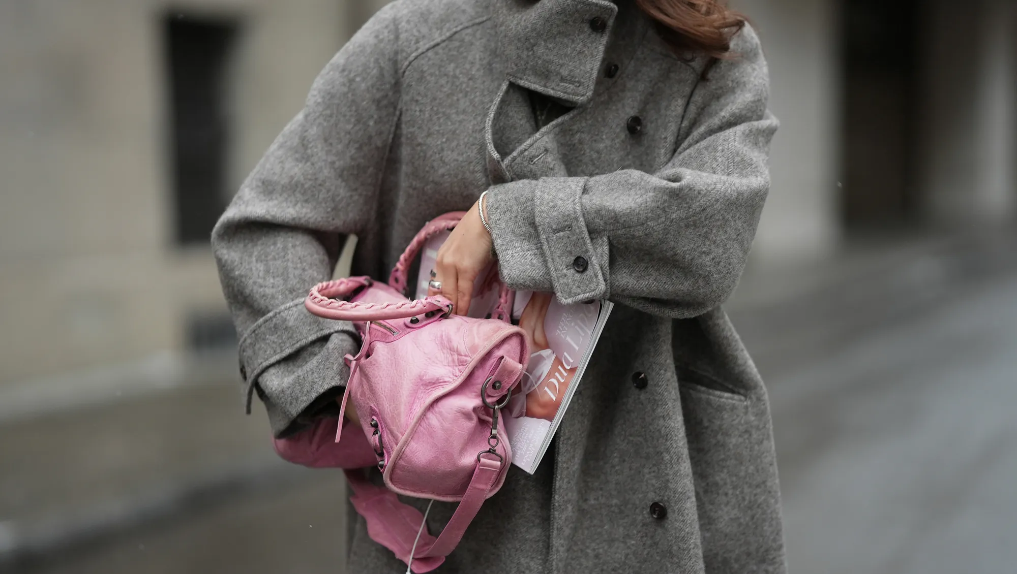 New Handbags MUNICH, GERMANY - JANUARY 8: Amanda M&uuml;hle is seen wearing a grey wool coat with wide lapels, button closure and buttoned collar from Siyazu; a pink leather Balenciaga &ldquo;City bag&rdquo; with a softly slouched shape, top handles and silver hardware from Balenciaga; multiple silver rings from Pilgrim; holding a Vogue Magazine on January 8, 2026 in Munich, Germany.