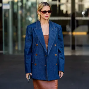 Helena Bordon wears denim blazer, brown dress, sunglasses, golden earrings outside Zimmermann during the Womenswear Fall/Winter 2024/2025 as part of Paris Fashion Week on March 04, 2024 in Paris, France.