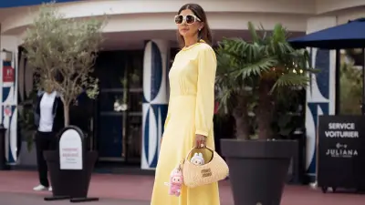 CANNES, FRANCE - MAY 17: Zufi Alexander wears an all Miu Miu look made of butter yellow long summer dress, off white pumps high heels with platform, sunglasses and straw Miu Miu bag with attached Labubu bag charms during day five of the 78th Cannes Film Festival on May 17, 2025 in Cannes, France. (Photo by Raimonda Kulikauskiene/Getty Images)