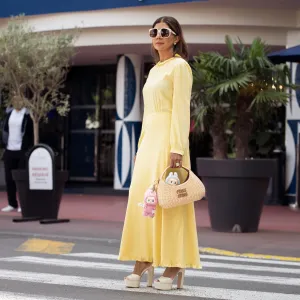CANNES, FRANCE - MAY 17: Zufi Alexander wears an all Miu Miu look made of butter yellow long summer dress, off white pumps high heels with platform, sunglasses and straw Miu Miu bag with attached Labubu bag charms during day five of the 78th Cannes Film Festival on May 17, 2025 in Cannes, France. (Photo by Raimonda Kulikauskiene/Getty Images)