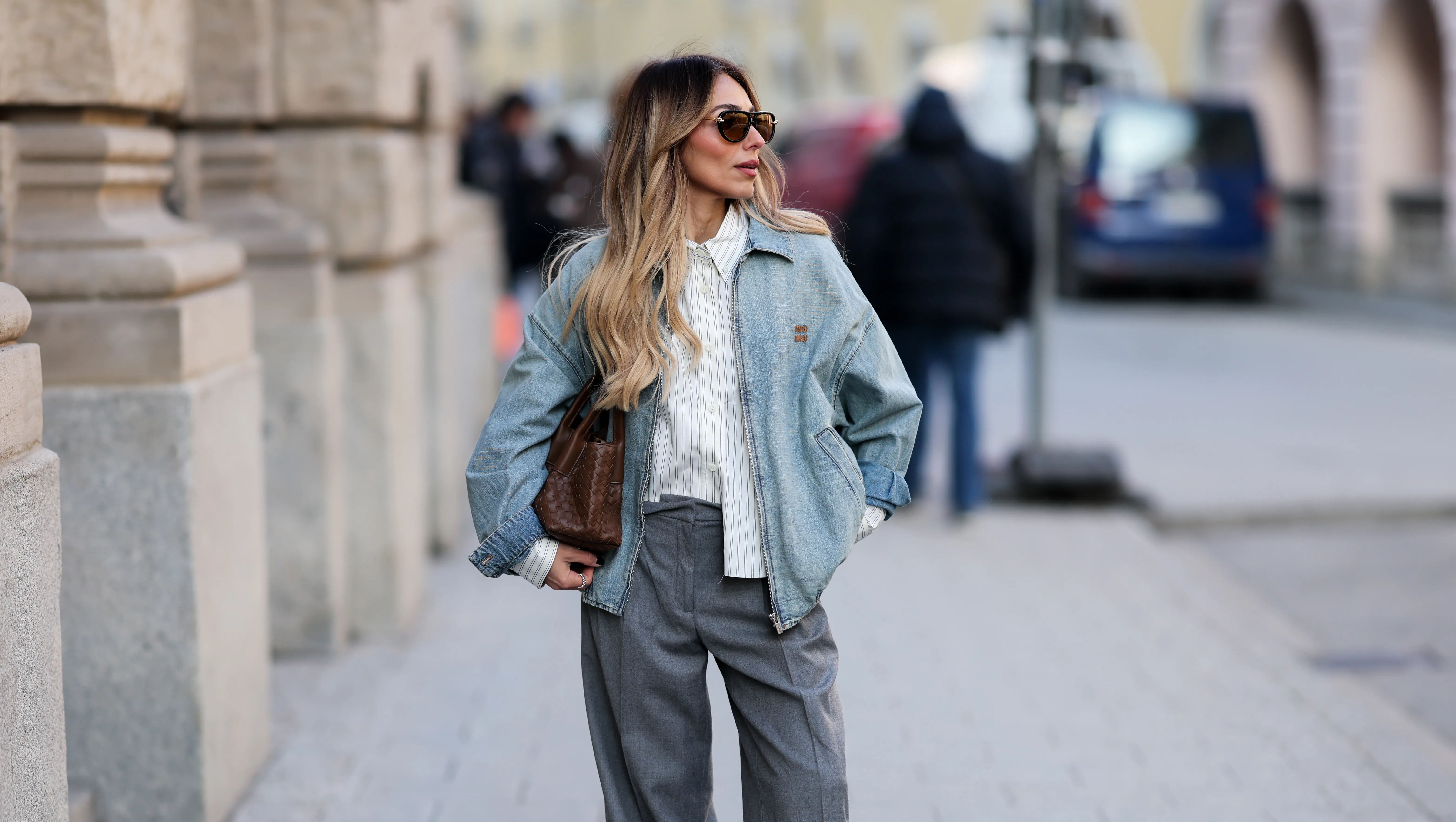 MUNICH, GERMANY - FEBRUARY 1: Oeznur Sinani alias Sinperi is wearing a light blue zip-up jacket by Miu Miu; a white shirt with blue stripes by Miu Miu; a wide-leg grey trousers by Windsor; New Balance X Miu Miu 530 SL mules in faded suede; black aviator sunglasses by Bottega Veneta; small silver hoop earrings by Cartier; a vintage tennis bracelet by Cartier; a gold Love bracelet by Cartier; gold and silver rings by Cartier; a wristwatch by Cartier; a light brown woven bag by Bottega Veneta; her blonde hair is styled in light waves on February 1, 2026 in Munich, Germany. (Photo by Moritz Scholz/Getty Images)