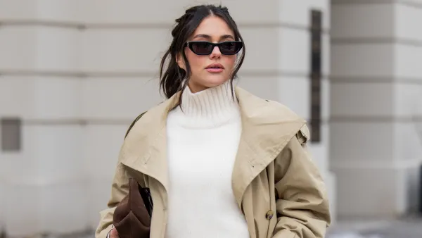 BERLIN, GERMANY - FEBRUARY 01: Aylin Sengül wears white jeans & beige trench coat Arket, turtleneck Cos, sunglasses YSL, loafers H&M, brown suede bag Demellier London during the Berlin Fashion Week Autumn/Winter 2026 at on February 01, 2026 in Berlin, Germany. (Photo by Christian Vierig/Getty Images)