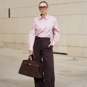 COPENHAGEN, DENMARK - AUGUST 05: Justyna Czerniak wears brown pants, pink shirt, sunglasses and brown suede bag during Copenhagen Fashion Week day two on August 05, 2025 in Copenhagen, Denmark. (Photo by Raimonda Kulikauskiene/Getty Images)
