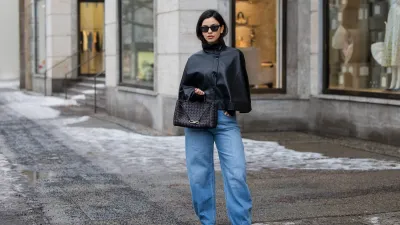 BERLIN, GERMANY - FEBRUARY 10: Bella Emar wears Gina Tricot black leather Cape, My essential wardrobe ripped jeans, flattered boots, black Bottega Veneta bag on February 10, 2026 in Berlin, Germany. (Photo by Christian Vierig/Getty Images)