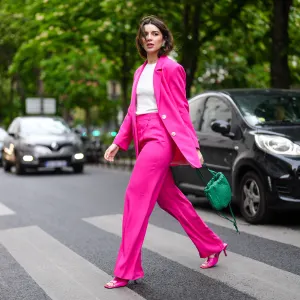 PARIS, FRANCE - MAY 05: Ketevan Giorgadze @katie.one wears a green The bulb woven leather bag from Bottega Veneta, a white tank top from Zara, a neon color loose-fitting oversized blazer jacket with a lapel collar, long sleeves and pronounced shoulders, front flap pockets in hot pink from Zara, high waisted masculine trousers with darts and a wide-leg flared design and front pockets from Zara, green vintage earrings, stretch leather sandals mules in pink from Bottega Veneta, on May 05, 2021 in Paris, France. (Photo by Edward Berthelot/Getty Images)