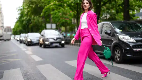 PARIS, FRANCE - MAY 05: Ketevan Giorgadze @katie.one wears a green The bulb woven leather bag from Bottega Veneta, a white tank top from Zara, a neon color loose-fitting oversized blazer jacket with a lapel collar, long sleeves and pronounced shoulders, front flap pockets in hot pink from Zara, high waisted masculine trousers with darts and a wide-leg flared design and front pockets from Zara, green vintage earrings, stretch leather sandals mules in pink from Bottega Veneta, on May 05, 2021 in Paris, France. (Photo by Edward Berthelot/Getty Images)