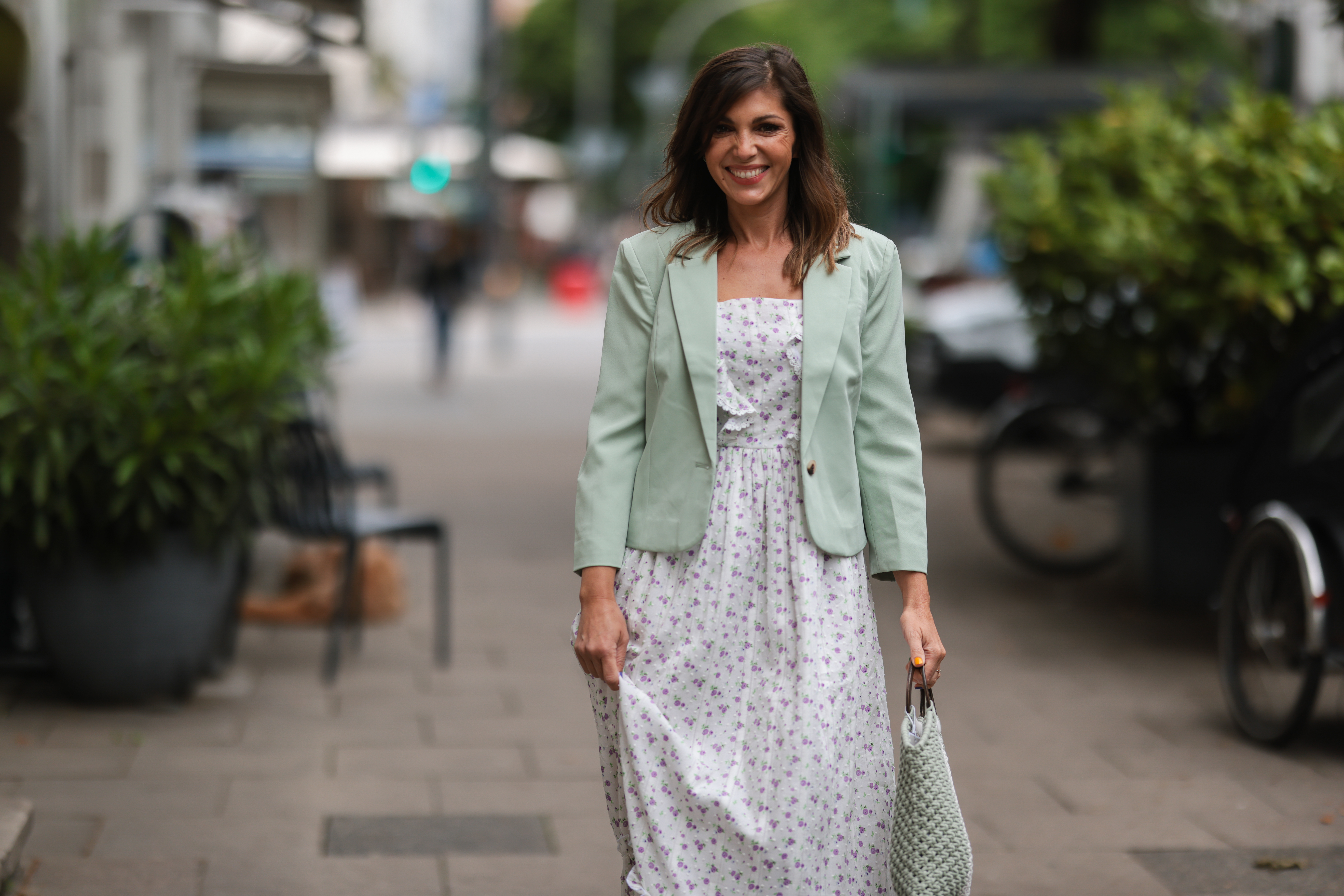 Anna Wolfers seen wearing a light green blazer, a long maxi dress with floral print and a white and light green crochet bag on June 02, 2022 in Hamburg, Germany.