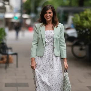 Anna Wolfers seen wearing a light green blazer, a long maxi dress with floral print and a white and light green crochet bag on June 02, 2022 in Hamburg, Germany.
