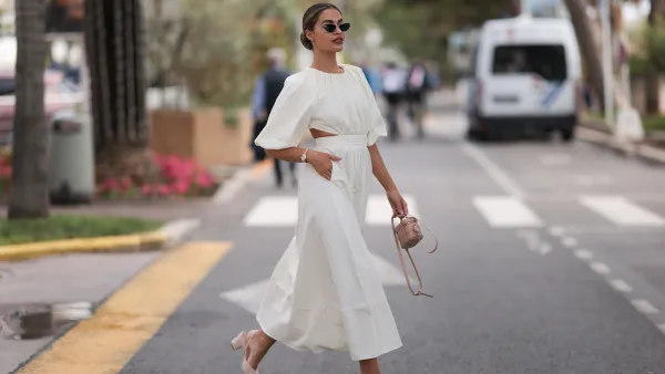 Jessica de Oliviera seen wearing Dior black sunglasses, Dior bag, Chanel heels, Rolex yellow gold watch and a flowy long dress with cutouts during the 76th Cannes film festival on May 21, 2023 in Cannes, France.