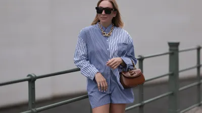 BERLIN, GERMANY - JUNE 28: Sonia Lyson wearing Gold Zara statement link chain, Storets matching two piece set includes a buttoned blue and white striped flannel and short, Linda Farrow brown big shades and Gucci bamboo brown leather wood bag on June 28, 2023 in Berlin, Germany. (Photo by Jeremy Moeller/Getty Images)