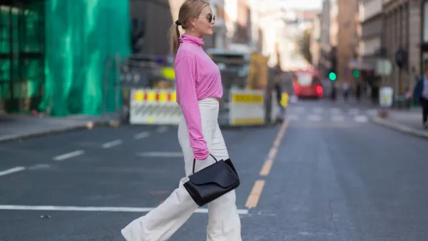 A guest wearing pink knit, white pants outside Line of Oslo on August 22, 2017 in Oslo, Norway.
