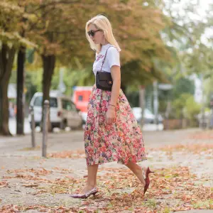 Sonia Lyson wearing a midi skirt with floral print Ganni, a white T-shirt with the print Love Dog from Ganni, a black Chanel vintage bag, vintage sunglasses, red Dior shoes on August 28, 2017 in Berlin, Germany.