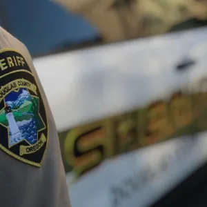 A Douglas County Sheriff's deputy stands near a patrol car