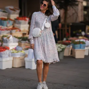 Anna Wolfers wearing brown shades, a pink floral midi dress and a white leather bag via goldigshop.de and white selected femme sneaker on March 25, 2022 in Hamburg, Germany.