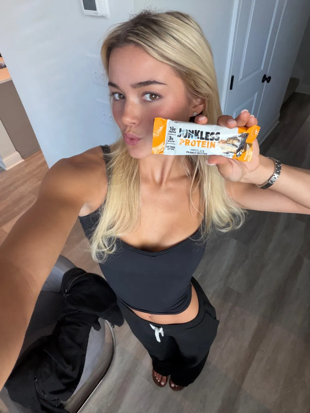 Olivia Dunne holding a junkless protein bar