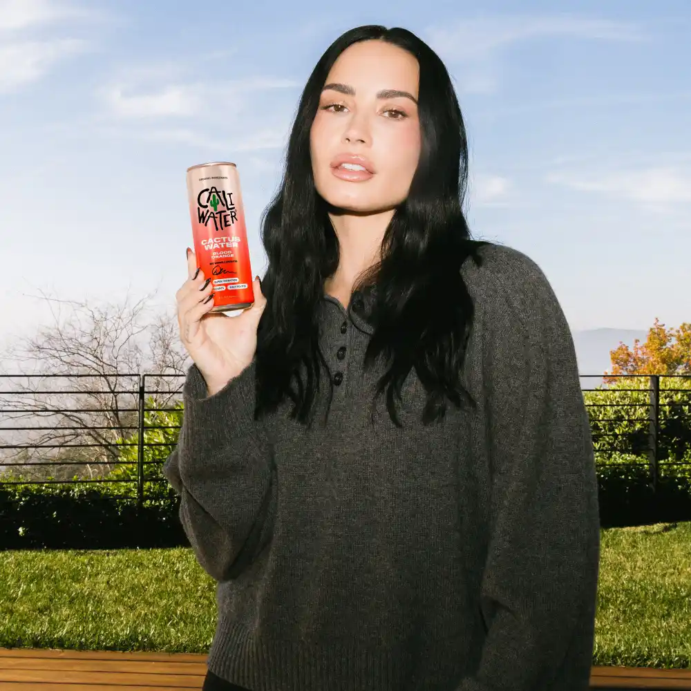 Demi Lovato holding a can of Caliwater.