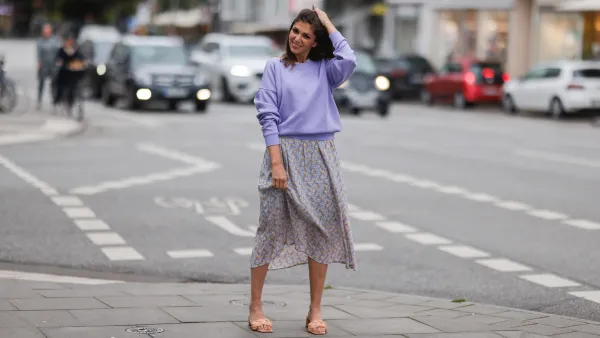 Anna Wolfers seen wearing a purple knit sweater, a light blue midi dress with floral print and light orange heels on June 02, 2022 in Hamburg, Germany.