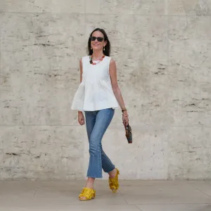 PARIS, FRANCE - MAY 02: Alba Garavito Torre wears black sunglasses, long straight brown hair with a center part, a white pleated peplum sleeveless blouse by Commense, and blue high-rise raw-hem denim jeans. A yellow clog sandal with floral detailing by AGL is worn, paired with a jean denim and brown mini Jackie handbag by Gucci. Accessories include a chunky necklace with colorful natural stones by Sempiterno Paris and gold jewelry. Full body shot, during a street style fashion photo session, on May 02, 2025 in Paris, France. (Photo by Edward Berthelot/Getty Images)