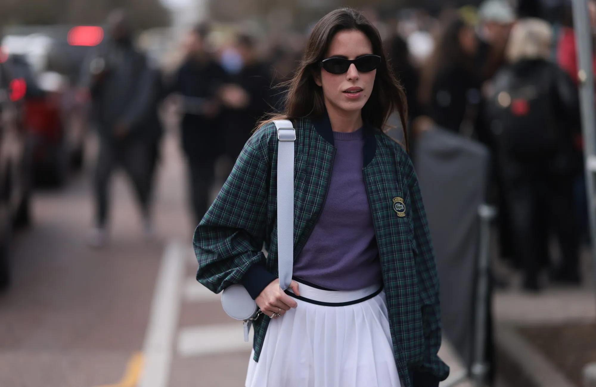PARIS, FRANCE - MARCH 05: Nina Urgell Cloquell seen wearing a white tennis skirt, green and black checkered Lacoste jacket, purple shirt, black shades, black leather loafer, pink socks and a white Lacoste bag outside Lacoste Show during the Womenswear Fall/Winter 2024/2025 as part of Paris Fashion Week on March 05, 2024 in Paris, France. (Photo by Jeremy Moeller/Getty Images)