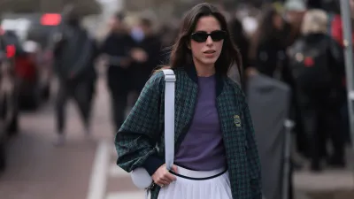 PARIS, FRANCE - MARCH 05: Nina Urgell Cloquell seen wearing a white tennis skirt, green and black checkered Lacoste jacket, purple shirt, black shades, black leather loafer, pink socks and a white Lacoste bag outside Lacoste Show during the Womenswear Fall/Winter 2024/2025 as part of Paris Fashion Week on March 05, 2024 in Paris, France. (Photo by Jeremy Moeller/Getty Images)