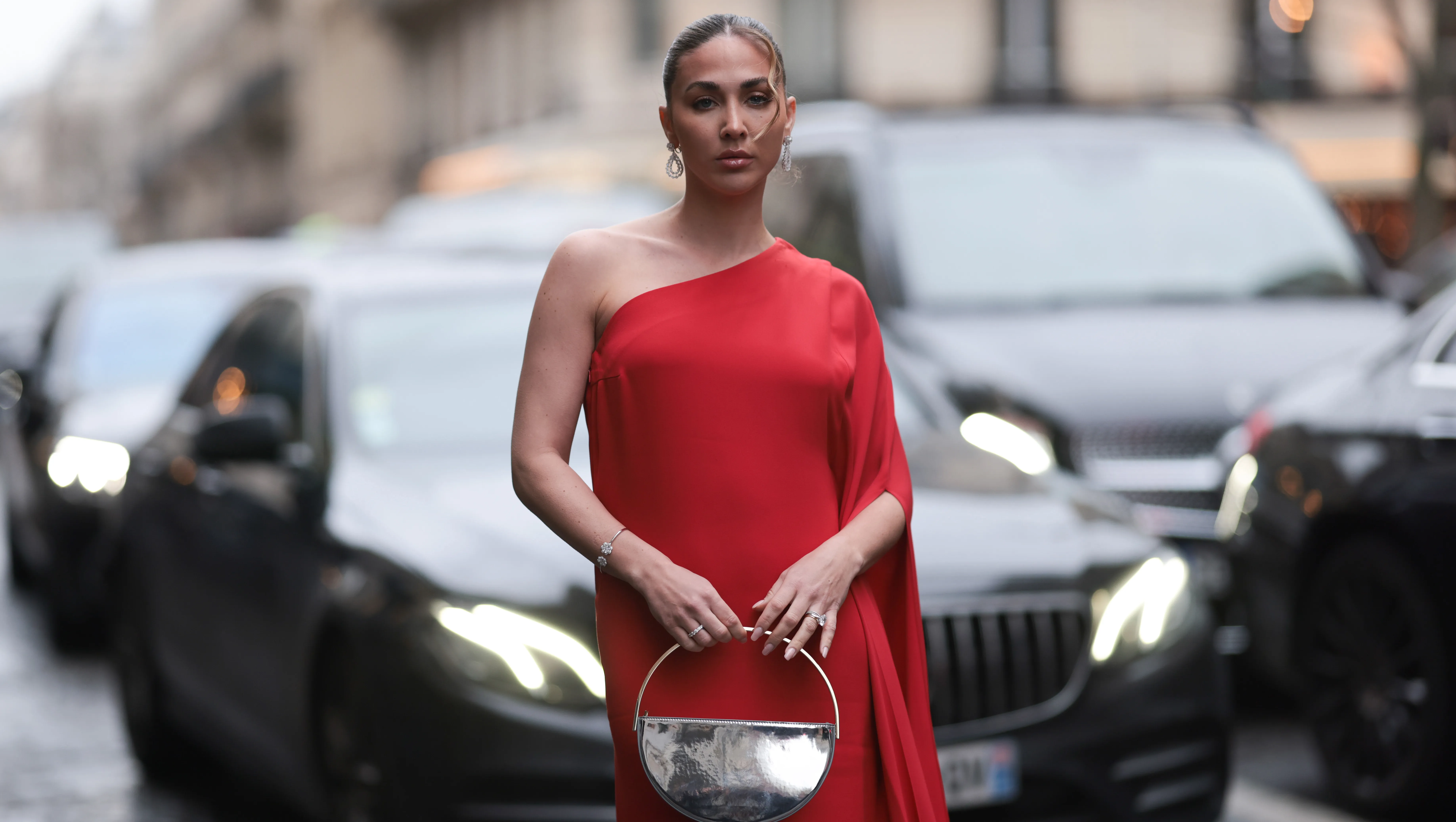 PARIS, FRANCE - JANUARY 23: Ann Kathrin Götze is seen wearing a long red dress with a train, gold hoop earrings by Chopard and a silver metallic handbag during the Stephane Rolland Show Haute Couture Spring/Summer 2024 as part of Paris Fashion Week on January 23, 2024 in Paris, France. (Photo by Jeremy Moeller/Getty Images)