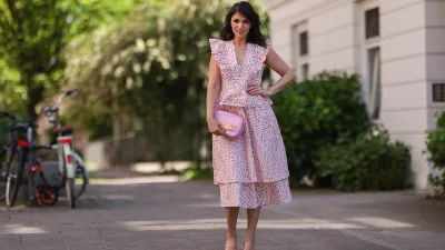 Anna Wolfers wearing white and pink ruffle dress via Goldig Shop, pink Moschino clutch and pink heels on May 31, 2021 in Hamburg, Germany.