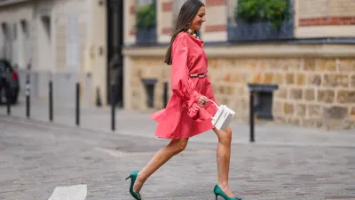 Alba Garavito Torre wears a pink mini dress with long sleeves from Natan, a pearl beaded necklace, earrings, a pearl beaded belt, a white Jacquemus El Chiquito bag, green high heeled shoes from Manolo Blahnik, on July 02, 2021 in Paris, France.