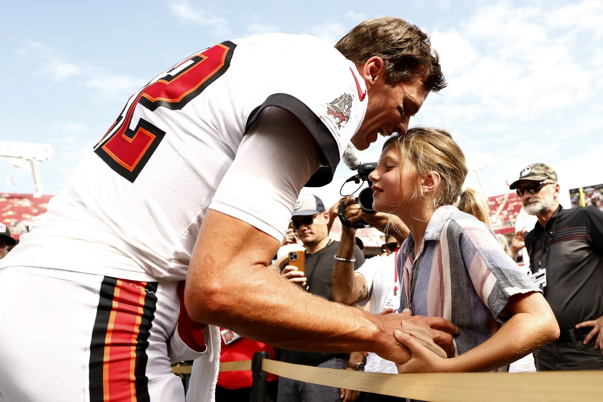 GettyImages-1427328428-Tom-Brady-Passes-Olympic-Torch-to-Daughter-Vivian-Lake-After-Ruling-Out-His-Own-Bid