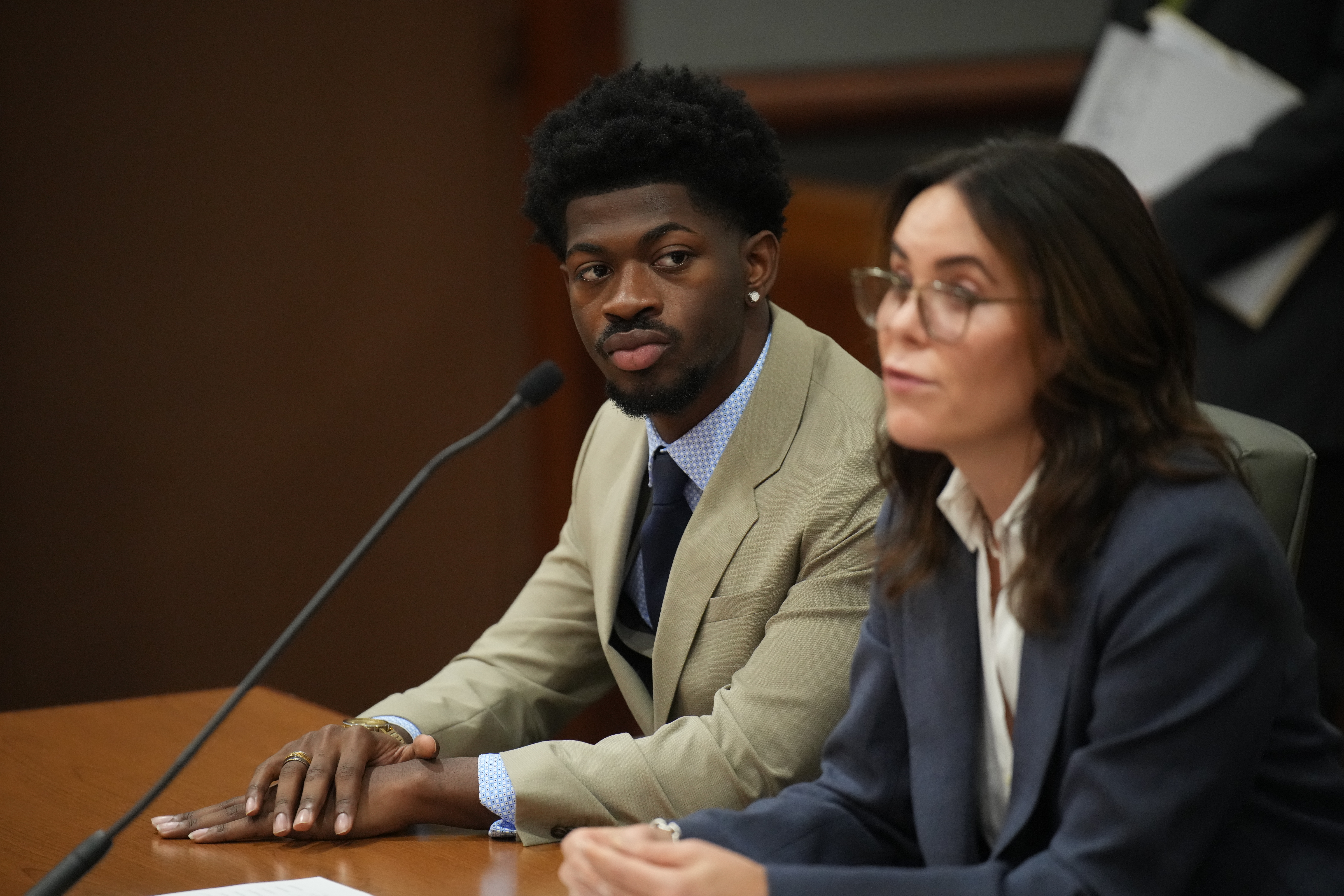 Lil Nas X sitting in court.