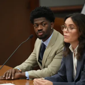 Lil Nas X sitting in court.