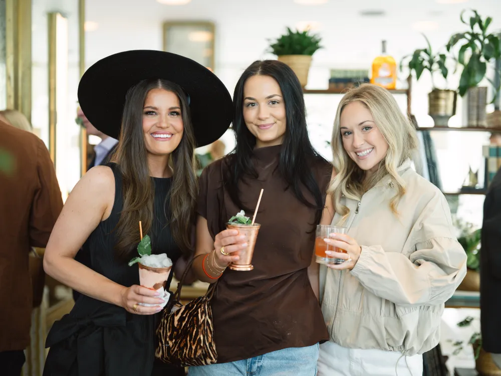 Three women enjoying drinks.
