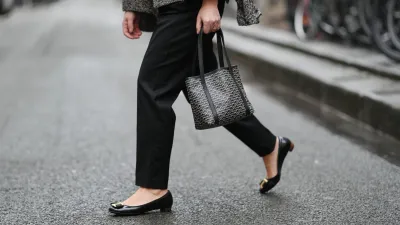 PARIS, FRANCE - JANUARY 12: Maria Rosaria Rizzo wears black Balmain tailored pants with a straight leg, black leather Salvatore Ferragamo ballerina flats with a rounded toe, golden detail and low profile sole, during a street style fashion photo session, on January 12, 2026 in Paris, France. (Photo by Edward Berthelot/Getty Images)