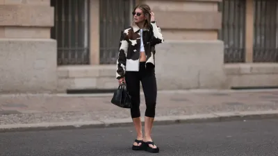 BERLIN, GERMANY - AUGUST 19: Sophia Geiss is seen wearing oval rimless black sunglasses from Vehla Eyewear, a silver nose ring, several silver hoop earrings, a cow hair jacket with the white and brown cow spot pattern from Samsøe Samsøe, a white cropped top underneath, a rectangular black leather bag with round handle from COS, black capri leggings pants from Mango, several rings in gold and silver, and black platform sandals from Zara on August 19, 2024 in Berlin, Germany. (Photo by Jeremy Moeller/Getty Images)