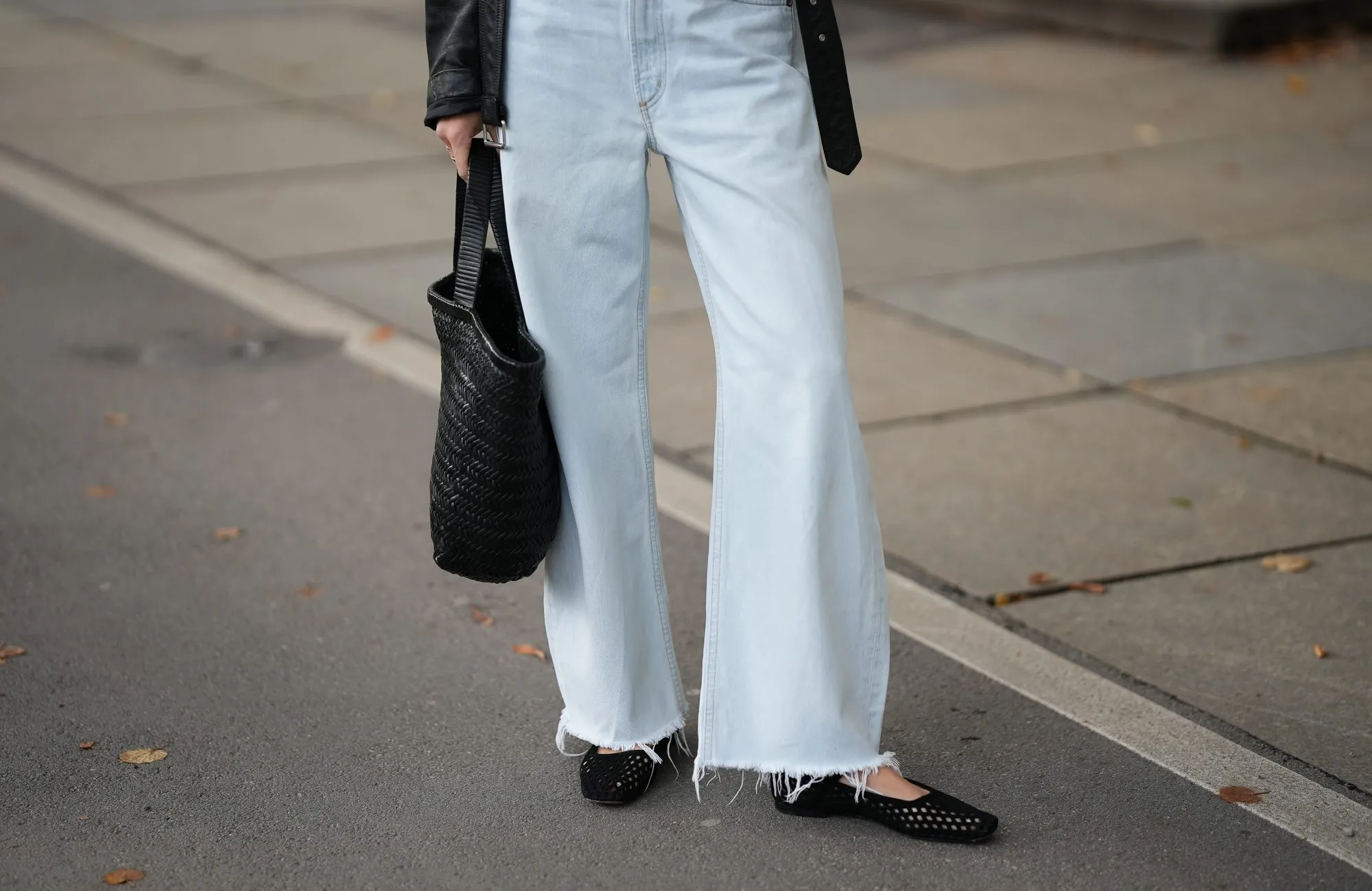 MUNICH, GERMANY - SEPTEMBER 2: Marlies Pia Pfeifhofer is seen wearing a pair of light blue wide-leg jeans with frayed hems from Agolde; a cropped black biker-style leather jacket with belt at the hem from Closed; a pair of black suede 9514 Camoscio mesh ballerinas with adjustable Mary Jane strap and square toe from Unützer; a black woven leather Klein Tote bag from Alex Rivière Studio x Manebí on September 2, 2025 in Munich, Germany. (Photo by Moritz Scholz/Getty Images)
