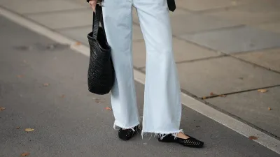 MUNICH, GERMANY - SEPTEMBER 2: Marlies Pia Pfeifhofer is seen wearing a pair of light blue wide-leg jeans with frayed hems from Agolde; a cropped black biker-style leather jacket with belt at the hem from Closed; a pair of black suede 9514 Camoscio mesh ballerinas with adjustable Mary Jane strap and square toe from Unützer; a black woven leather Klein Tote bag from Alex Rivière Studio x Manebí on September 2, 2025 in Munich, Germany. (Photo by Moritz Scholz/Getty Images)