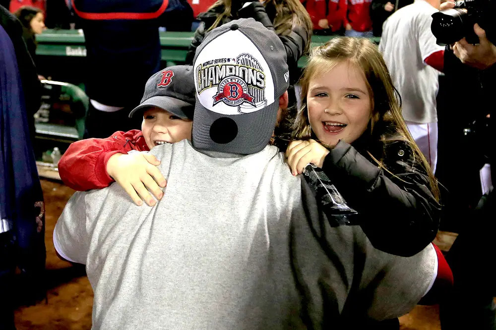 David Ross #3 of the Boston Red Sox hugs his children Landri (R) and Cole (L) following a 6-1 victory over the St. Louis Cardinals in Game Six of the 2013 World Series at Fenway Park on October 30, 2013 in Boston, Massachusetts.
