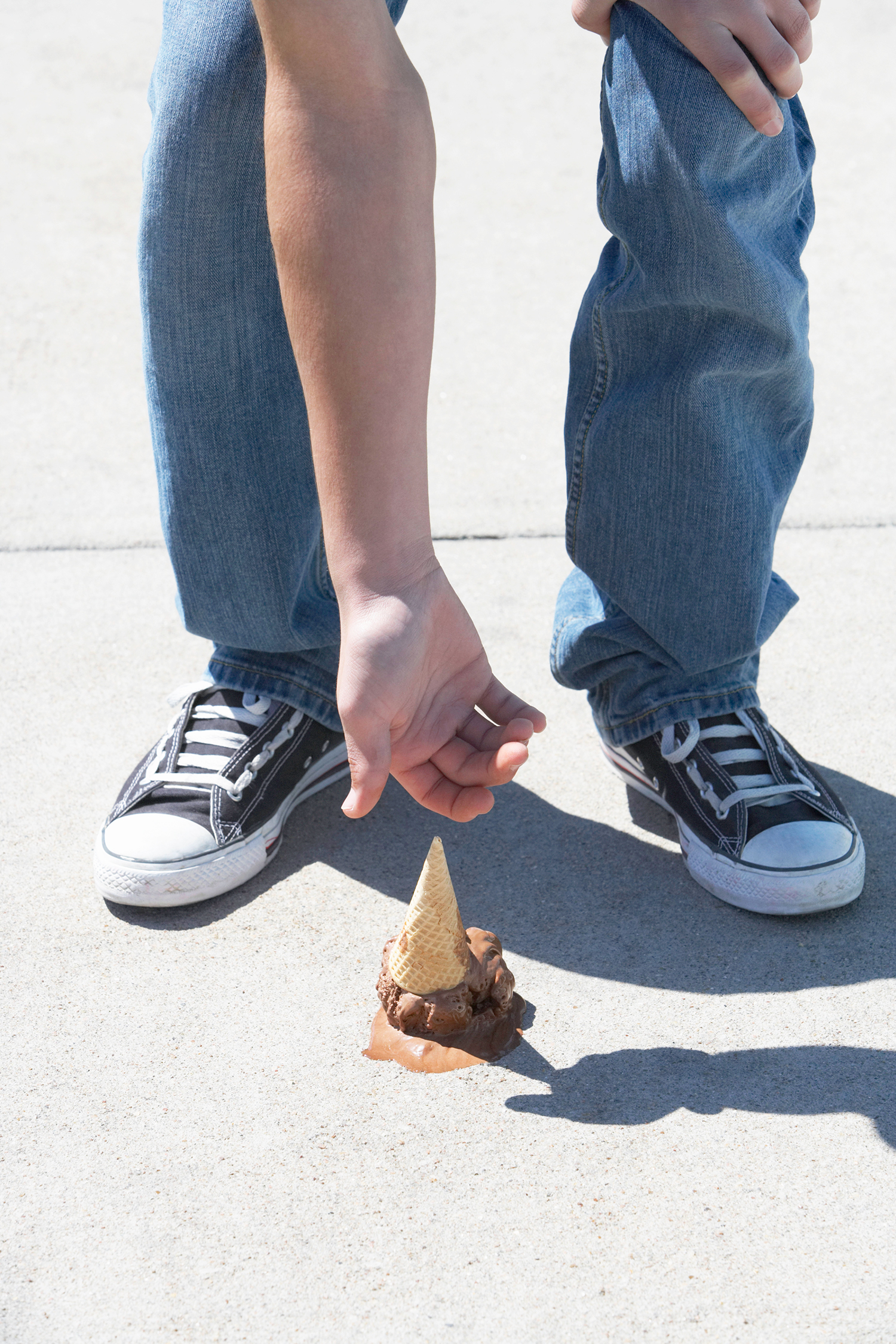 Young Man Reaching for Dropped Ice Cream Cone