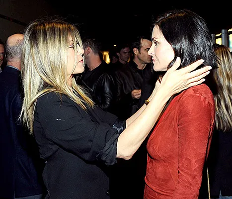 Jennifer Aniston and Courteney Cox (touching hair)