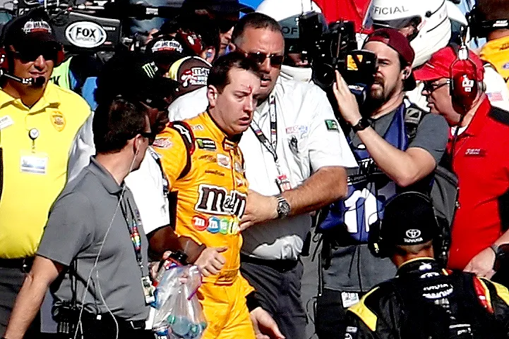 Kyle Busch, driver of the #18 M&M's Toyota, is escorted away by a NASCAR official after an incident on pit road with Joey Logano (not pictured), driver of the #22 Pennzoil Ford, following the Monster Energy NASCAR Cup Series Kobalt 400 at Las Vegas Motor Speedway on March 12, 2017 in Las Vegas, Nevada.