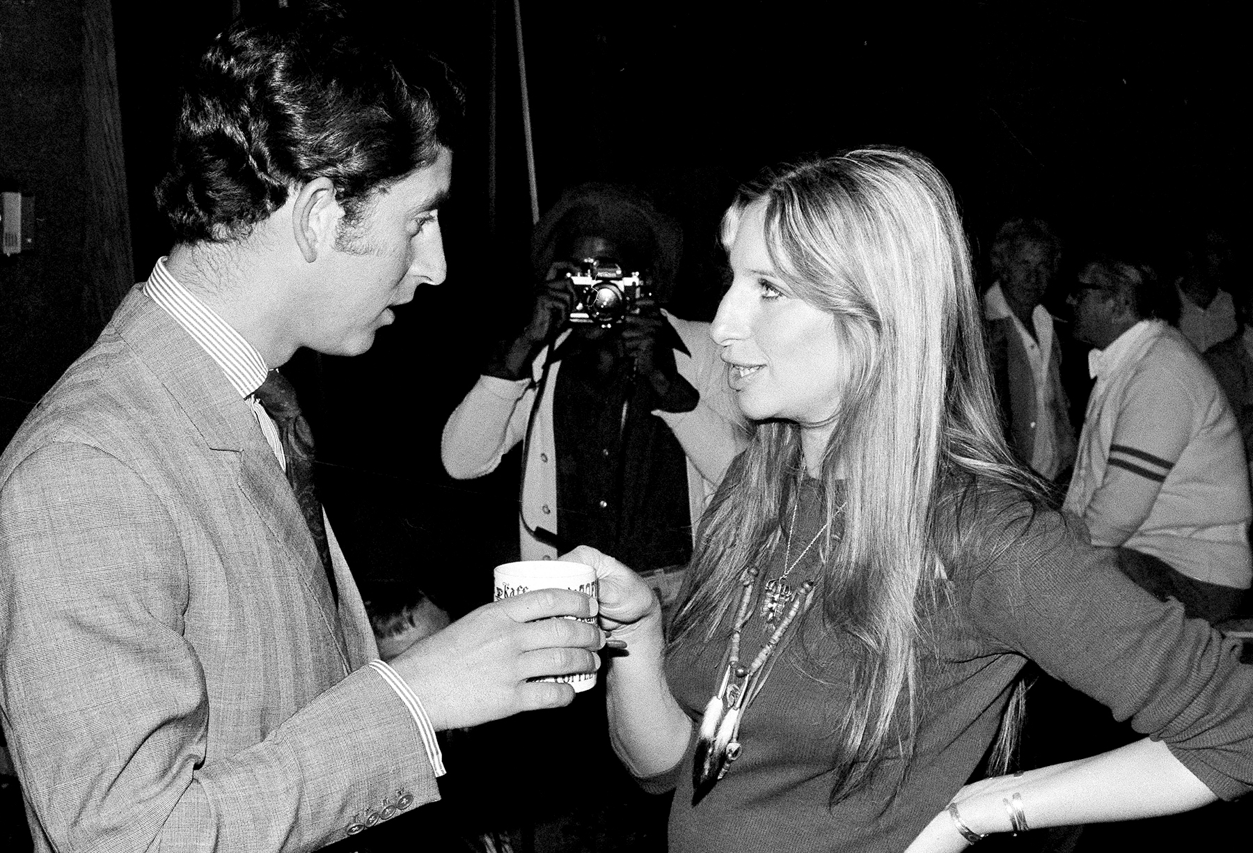 Barbra Streisand offers a cup of coffee to Prince Charles of Great Britain as they chat on a set at Warner Bros. studio in Los Angeles, CA, March. 19, 1974.