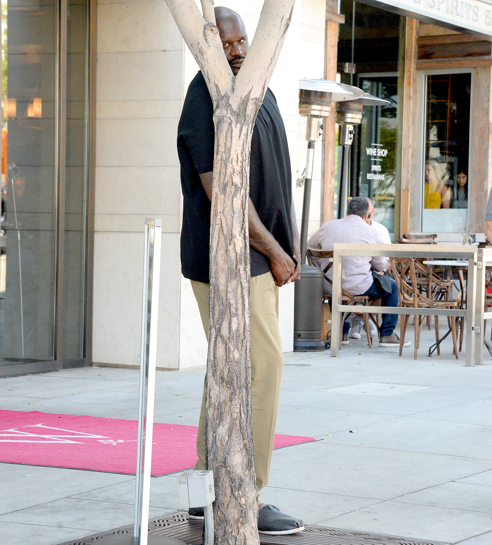 Shaquille O'Neal does his best to hide from paparazzi as he waits for his car after lunch at Wolfgang's Steakhouse in Beverly Hills.