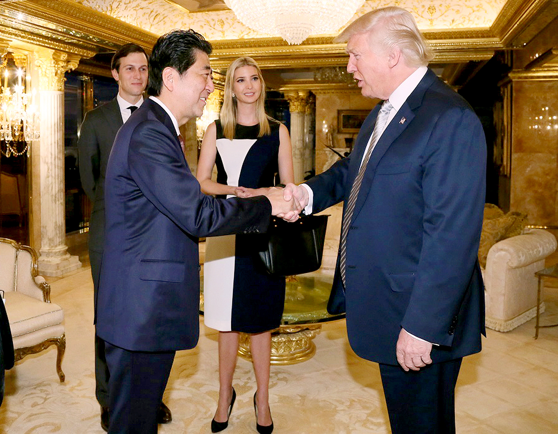 Japanese Prime Minister Shinzo Abe, front left, shakes hands with U.S. President-elect Donald Trump during a meeting as Ivanka Trump, back right, the oldest daughter of Donald Trump, and her husband, Jared Kushner, back left.