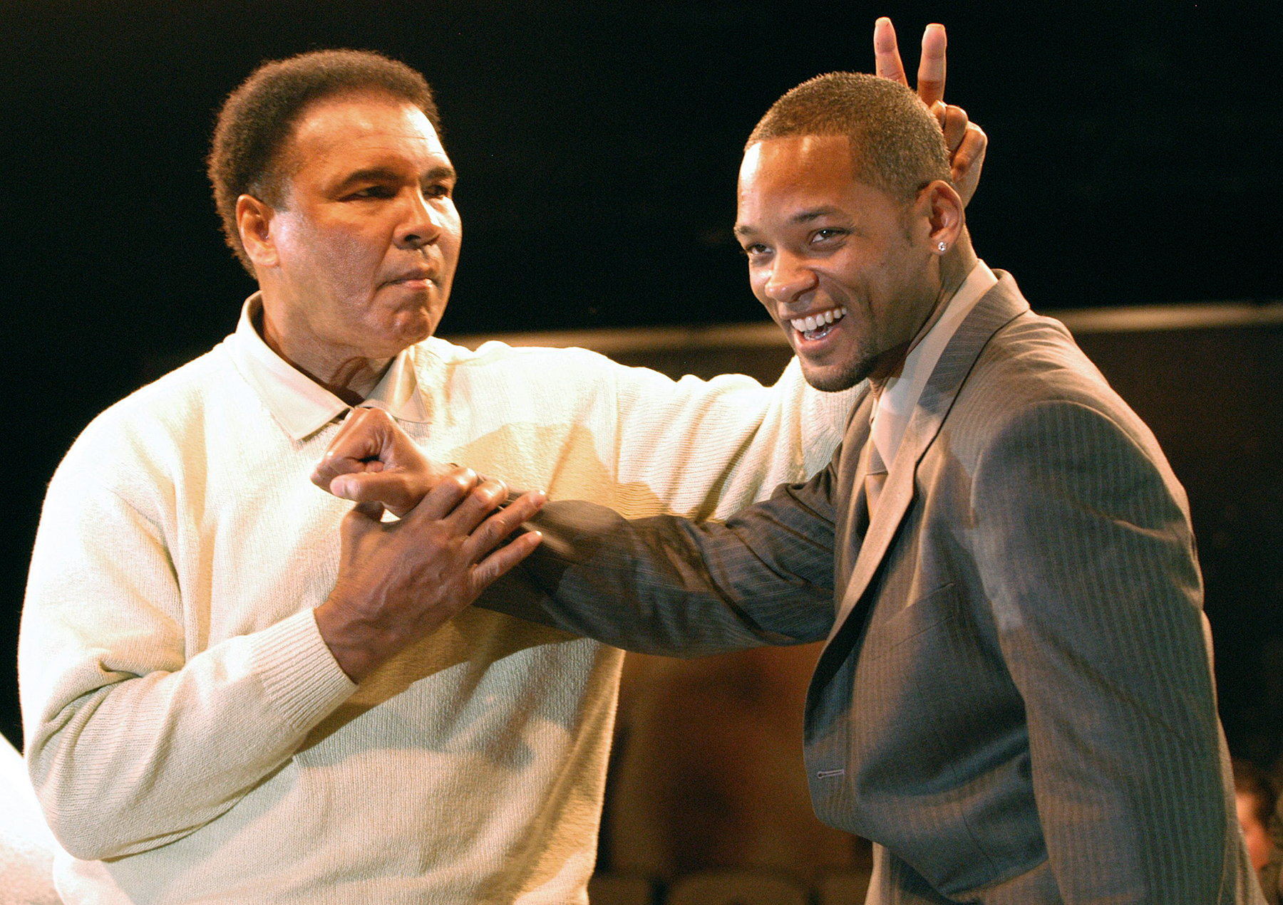 Muhammad Ali gestures behind the head of actor Will Smith at the Miami Art Basel Taschen book premiere of Ali's new book, 'GOAT - Greatest Of All Time' at the Miami Convention Center December 6, 2003 in Miami, Florida.